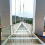Stunning glass bridge with panoramic mountain views, perfect for adventurous tourists.