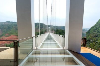 Stunning glass bridge with panoramic mountain views, perfect for adventurous tourists.