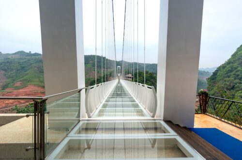 Stunning glass bridge with panoramic mountain views, perfect for adventurous tourists.